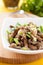 Pickled honey agarics and green onions in a white bowl