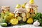 Pickled patissons, cucumbers with carrots and garlic in glass jars and fresh ingredients on a gray background