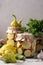 Pickled patissons, cucumbers with carrots and garlic in glass jars and fresh ingredients on a light gray background, Vertical