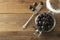 Pickled pitted black olives in glass jar, wooden background. Mediteranian foods. Copy space