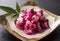 Pickled shiso garlic served on a plate placed on a black background