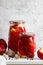 Pickled sweet peppers in glass jars on a light surface