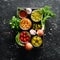 Pickled vegetables and mushrooms in glass jars in Wooden box on black stone background.