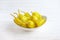 Pickled yellow greek pepper, pepperoncini or friggitelli in bowl on white wooden background