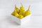 Pickled yellow greek pepper, pepperoncini or friggitelli in bowl on white wooden background