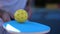 Pickler rolling a perforated plastic ball on a racket