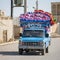 Pickup car loaded with colorful mattresses rides around the streets