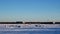 Pickup truck drives past Winter Fishing Houses on frozen Lake Bemidji in Minnesota on a late December afternoon.