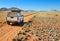 Pickup truck driving on desert road towards the Tiras mountains