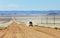 Pickup truck driving fast on long straight desert road