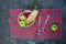 Picnic basket with wine glass and fruits on checkered cloth on rocks. Romantic still life of autumn or summer outing, lunch at