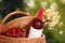 Picnic basket with wine, strawberries and flowers on blurred background