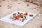 Picnic on the beach at sunset in the white plaid, food and drink