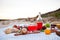 Picnic on the beach at sunset in the white plaid, food and drink