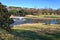 Picnic bench along a lake with a fountain throwing water into the air