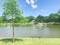 Picnic bench looking at clear pond with floating decorative water fountain at local park in Coppell, Texas, USA