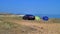 Picnic by the black car on the parched meadow