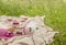 Picnic blanket with wine glasses, rose wine, candles, sun hat, fresh berries and baguette on green grass. Romantic brunch outdoor