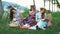 Picnic in the countryside. Women friends enjoying picnic, reading books, writing in notebook