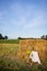 Picnic in the field near straw bales. The setting sun. Rustic style - wood chair, plaid, bouquet of flowers, mirror. Romantic date