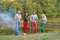 Picnic with friends in at lake near bonfire. Company friends having hike picnic nature background. Hikers relaxing during drink