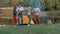 Picnic group of friends with bonfire on the beach in the evening. Cheerful friends dancing and playing guitar. Slowmotion shot