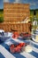 Picnic hamper on a striped blanket with wine, bread and mixed berries in a meadow with blue skies