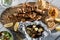 A picnic meal of grilled skewers, Greek salad, baby potatoes and tzatziki dip.