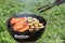 Picnic outdoors in the summer. Cooking on a round grill fish sea bass and zucchini slices