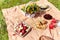 Picnic at the park on the grass: tablecloth, basket, healthy food and accessories.