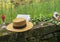 Picnic in the park with mountains landscape. Straw hat, open book, glass with fruits. Copy space