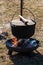 Picnic place with a campfire, firewood and boiler with lid in sunny spring day