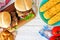 Picnic scene with hamburgers, corn and potato wedges
