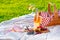 Picnic setting in a meadow. Picnic basket, wine, berries, jamon, cheese and bread