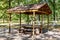 Picnic site in park. Wooden table and benches in green forest