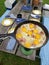 Picnic table with a frying pan cooking bacon and eggs