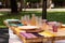 picnic table set with wooden plates, glasses, and silverware