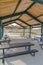 Picnic tables with benches inside a pavilion