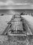 Picnic tables with benches on Whitstable beach in monochrome