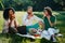 Picnic of three multi race friends. Beautiful african woman and her caucasian male and female friends are enjoying the