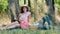 Picnic time. Happy young couple sitting and smiling outdoors. Man laying on her hands. Outdoors in the park