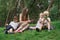 Picnic with whole family - mom and three children sitting on picnic blanket. Big happy family