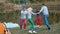 Picnic of young people with bonfire on the beach in the evening. Cheerful friends dancing around bonfire. Slowmotion shot