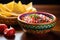 pico de gallo in a vibrant ceramic bowl with chips nearby