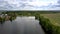 Pictorial blue river flows between small village and field