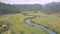 Pictorial calm blue river reflects trees near green fields