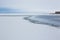 Pictorial landscape of frozen river and endless blue sky with thick clouds