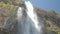 Pictorial large waterfall under clear blue sky slow motion