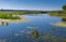 Pictorial summer landscape with small river Merla and flock of home geese