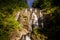 Pictorial Waterfall on Rocks between Tropical Jungle